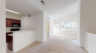 Located at 5515 53rd St in Lubbock, TX, this single-story home offers a well-organized layout with a bright, neutral palette throughout. The entry foyer welcomes visitors with light tile flooring and a large window fitted with blinds, transitioning seamlessly into the main living areas via plush carpeting.

The living room is a standout space, featuring vaulted ceilings that enhance the sense of openness, a ceiling fan with light fixture, and a fireplace with a classic white mantel that serves as a focal point. Large windows along the front wall invite abundant natural light, creating an airy atmosphere. A half-wall partition subtly defines the transition between living zones while maintaining an open feel.

Adjacent to the living area, the kitchen is appointed with rich dark wood cabinetry, white countertops, tile flooring, and black appliances including an electric range, over-the-range microwave, and dishwasher, complemented by a stainless steel sink.

The bedroom provides a comfortable, carpeted retreat with its own ceiling fan, natural light from a window with blinds, and clean white walls. The bathroom features a wide vanity with a large mirror, extended cabinetry for storage, tile flooring, and bright overhead lighting, maintaining the home's consistent clean and functional aesthetic.