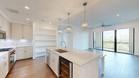 Located in Houston's desirable Montrose area, this well-appointed 2-bedroom, 2-bathroom residence offers a thoughtfully designed single-floor layout with clean, modern finishes throughout. Light-toned hardwood flooring flows seamlessly across the living areas and bedrooms, creating a cohesive and airy atmosphere. The combined kitchen and living room serves as the heart of the home, where the kitchen impresses with white shaker cabinetry extending to the ceiling, quartz countertops, a marble-style tile backsplash, stainless steel appliances including a gas range, built-in microwave, and French door refrigerator, plus convenient open shelving. The living room opens directly onto a private balcony through floor-to-ceiling sliding glass doors, filling the space with natural light and offering elevated views of the surrounding Houston skyline and greenery. Ceiling fans are present throughout. The spacious primary bedroom features a large window with outdoor views and a tray ceiling detail, while its en-suite bathroom boasts marble-look tile flooring, a white vanity with quartz counters, a frameless glass shower, and direct access to a walk-in closet with custom shelving. The second bedroom is bright and well-sized with its own window. A second full bathroom mirrors the refined finishes found elsewhere in the home.