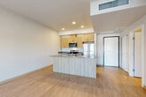 Located at 953 Hodgin St in Sedro-Woolley, WA, this thoughtfully designed one-bedroom, one-bathroom residence offers a clean, modern aesthetic across a well-utilized single-floor layout. Light-toned luxury vinyl plank flooring flows throughout the main living areas, complementing the bright, neutral color palette that gives the space an open and airy feel.

The kitchen serves as a functional centerpiece, featuring an island with a gray laminate countertop and an integrated sink, light wood cabinetry with sleek hardware, and a full suite of stainless steel appliances including a refrigerator, range, microwave, and dishwasher. Recessed lighting illuminates the space effectively.

The living room is generously proportioned with plank flooring, neutral walls, and a sliding glass door that opens to a private balcony, allowing natural light to pour in and providing outdoor access.

The bedroom offers comfortable carpeting, a window with natural light, and direct access to a spacious walk-in closet equipped with wire shelving and hanging rods for ample storage.

The bathroom is finished with warm wood cabinetry, a gray countertop vanity, a framed mirror, and stylish overhead lighting. A stacked in-unit washer and dryer is conveniently located adjacent to the bathroom, adding everyday practicality to this well-appointed residence.