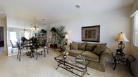 Located at 454 Heather Dr in Mantua, New Jersey, this single-floor home offers a welcoming and well-maintained interior designed for comfortable everyday living. The living area is carpeted in a neutral tone, creating a warm and inviting atmosphere that flows naturally into the adjacent dining space. The living room features clean white walls with visible ceiling vents for climate control, and is appointed with ample room for seating and entertaining. A glass-topped coffee table with ornate metal detailing anchors the space, complementing the plush, cushioned sofa. Decorative elements, including framed wall art and lush indoor plants, add character and warmth throughout. The dining area is defined by an elegant chandelier with classic styling and is furnished with a wrought-iron and glass dining set, giving it a refined yet casual feel. Mirrored surfaces near the dining space enhance the sense of openness and reflect natural and ambient light throughout the area. Open shelving units display curated décor items, contributing to the home's cohesive and tasteful aesthetic. Overall, the interior presents a cohesive, traditionally styled living environment that is both functional and visually appealing, ideal for those seeking a well-appointed single-level residence in Mantua, NJ.
