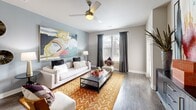 This contemporary 750 square foot apartment offers a thoughtfully designed living space with one bedroom and one bathroom. The open-concept layout seamlessly integrates the kitchen, living, and dining areas, creating a spacious feel despite the compact footprint.

The kitchen boasts sleek dark wood cabinetry, stainless steel appliances, and granite countertops with a breakfast bar. Pendant lighting adds a modern touch, while the adjacent dining area provides space for casual meals or entertaining.

The living room features large windows that flood the space with natural light, complemented by a ceiling fan for air circulation. A bold area rug anchors the seating area, which includes a comfortable sofa and accent chairs. Artistic elements, such as the vibrant wall art, add character to the neutral color palette.

The bedroom, measuring 140 square feet, continues the modern aesthetic with a upholstered headboard, matching nightstands, and table lamps. Striped curtains frame the windows, while abstract artwork adorns the accent wall, creating a serene yet stylish atmosphere.

The bathroom showcases a glass-enclosed shower, dark wood vanity, and contemporary fixtures. Throughout the apartment, wood-look flooring unifies the space, while strategic lighting enhances the overall ambiance.

This well-appointed apartment combines functionality with aesthetic appeal, offering a comfortable and sophisticated living environment in a compact urban setting.