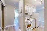 This 1-bedroom, 1-bathroom unit in Chilliwack, BC offers a practical and comfortable layout spread across a single floor. Light-toned laminate flooring flows throughout the space, creating a bright and cohesive feel. The living room is generously sized, featuring a sliding glass door that opens to a private balcony overlooking a residential neighbourhood — allowing natural light to fill the room. Baseboard heating is present throughout, ensuring year-round comfort. The kitchen is efficiently designed with white cabinetry, a tile backsplash, ample upper cabinet storage, and full-size white appliances including a coil-top range and refrigerator. A hallway connects the main living area to the bedroom, which offers a comfortable footprint, a large window that brings in natural light and neighbourhood views, and a full-width sliding mirrored closet providing excellent storage. Neutral warm-beige tones on the walls complement the light flooring throughout, giving the unit a clean and move-in ready appearance. The textured ceilings and clean white trim add a classic finishing touch, making this an inviting and functional space in a residential Chilliwack location.