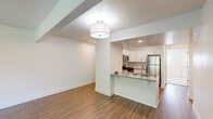 Located at 1124 Billings Ct SE in Grand Rapids, Michigan, this single-floor home offers a clean, modern aesthetic with thoughtfully updated finishes throughout. The open-concept living and kitchen area serves as the heart of the home, where warm wood-look flooring flows seamlessly underfoot. The kitchen is well-appointed with crisp white shaker-style cabinetry, a classic subway tile backsplash, neutral countertops, and a full suite of stainless steel appliances including a gas range, over-the-range microwave, and refrigerator. A peninsula with a built-in sink provides additional workspace and a natural division between the kitchen and the living area. The living room is generously sized and benefits from a sliding glass door that invites abundant natural light and offers views of the outdoor greenery. The bedrooms feature plush wall-to-wall carpeting and ceiling fans, lending a comfortable, quiet atmosphere. Windows throughout allow natural light to brighten each room. One bedroom includes a connected bathroom with a vanity and ample cabinetry, adding a convenient en-suite quality. The overall design is bright and neutral, creating a versatile canvas well-suited for a variety of living arrangements.