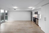 Located at 18 Tretti Way in Toronto's sought-after North York neighbourhood, this one-bedroom unit offers a thoughtfully designed open-concept layout across a single floor. Light-toned laminate flooring runs throughout, lending a clean, cohesive aesthetic to the entire space. The combined kitchen and living area forms the heart of the unit, where large windows and a sliding glass door flood the room with natural light and provide direct access to a balcony with views of the surrounding community. The kitchen is outfitted with sleek flat-front white cabinetry extending to the ceiling for generous storage, white quartz countertops, a tile backsplash, and a full suite of stainless steel appliances including a refrigerator, electric range, over-the-range microwave, and dishwasher. The open living area offers a versatile, spacious feel with crisp white walls and a clean-lined design. The bedroom is a well-proportioned private retreat, complete with a mirrored sliding-door closet featuring built-in wire shelving and a window that brings in natural light. Throughout the unit, the neutral white palette and modern finishes create a bright, contemporary ambiance well-suited to urban living.