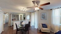 This single-floor residence offers a thoughtfully designed layout that balances comfort and functionality throughout. Rich hardwood-style flooring flows consistently across the living spaces, anchoring the warm, neutral color palette found in every room.

The living area is generously proportioned, featuring a ceiling fan with light fixture, textured ceiling, and large windows dressed with sheer curtains that allow abundant natural light to fill the space. A sliding glass door provides additional brightness and outdoor access. The adjacent dining area connects seamlessly to the living room, creating an open, social atmosphere.

The kitchen is outfitted with dark cabinetry, granite countertops, a double basin sink, and black appliances, including a refrigerator and dishwasher. A pass-through counter connects it to the dining area, and an in-unit laundry area is conveniently nearby.

Both bedrooms are comfortably sized, each featuring large windows that invite natural light and outdoor views. One bedroom includes a spacious walk-in closet with wire shelving systems offering ample storage.

The two bathrooms each feature granite-topped dark vanities, hardwood-style flooring, and shower-tub combinations, maintaining a consistent, refined aesthetic throughout the residence.