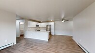 Located at 204 Oconnell St in Fox Lake, Wisconsin, this single-floor, 3-bedroom, 3-bathroom home offers a well-designed layout with modern finishes throughout. The open-concept living room is bright and welcoming, with large sliding glass doors that fill the space with natural light and provide outdoor views, complemented by light hardwood-style flooring and baseboard heating. The kitchen is a standout feature, boasting white shaker cabinetry, granite-look countertops, a central island, stainless steel appliances including a refrigerator, range, and microwave, along with recessed lighting and a ceiling fan. Each of the three bedrooms is generously sized — the primary bedroom is notably spacious — with plush carpeting, ceiling fans, and windows that invite natural light. The bathrooms are finished with white cabinetry, granite-look vanity tops, and hardwood-style flooring; one features a walk-in shower, while another includes a shower-tub combination. A walk-in closet with wire shelving provides ample storage off the primary suite. The home also includes two dedicated laundry areas equipped with front-loading GE washer and dryer units. Clean, neutral tones and consistent finishes create a cohesive and move-in-ready atmosphere throughout.