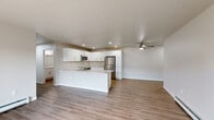 Located at 204 Oconnell St in Fox Lake, Wisconsin, this single-floor, 3-bedroom, 3-bathroom home offers a well-designed layout with modern finishes throughout. The open-concept living room is bright and welcoming, with large sliding glass doors that fill the space with natural light and provide outdoor views, complemented by light hardwood-style flooring and baseboard heating. The kitchen is a standout feature, boasting white shaker cabinetry, granite-look countertops, a central island, stainless steel appliances including a refrigerator, range, and microwave, along with recessed lighting and a ceiling fan. Each of the three bedrooms is generously sized — the primary bedroom is notably spacious — with plush carpeting, ceiling fans, and windows that invite natural light. The bathrooms are finished with white cabinetry, granite-look vanity tops, and hardwood-style flooring; one features a walk-in shower, while another includes a shower-tub combination. A walk-in closet with wire shelving provides ample storage off the primary suite. The home also includes two dedicated laundry areas equipped with front-loading GE washer and dryer units. Clean, neutral tones and consistent finishes create a cohesive and move-in-ready atmosphere throughout.