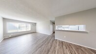 Located at 1105 S Wheeling St in Oregon, OH, this 2-bedroom, 1-bathroom unit offers a practical and well-designed single-floor layout. The open-concept main living area seamlessly combines the living room, dining room, and kitchen into one connected space. Light gray LVP flooring runs throughout the common areas, complemented by neutral gray walls and white trim, creating a clean and cohesive aesthetic. A large window in the living room allows natural light to fill the space, while a wall-mounted A/C unit and baseboard heaters provide year-round climate control. The kitchen features white cabinetry and appliances, accessible via a pass-through countertop that opens to the living and dining areas. Both bedrooms are carpeted in neutral gray tones and include natural light from windows, baseboard heating, and generous closet space — with the primary bedroom offering a walk-in closet. The unit includes an impressive five closets in total, providing abundant storage throughout. The bathroom is finished with a full tub-shower combination featuring white tile surround. The textured ceilings and consistent neutral palette give the entire unit a move-in-ready, well-maintained character.