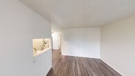 This one-bedroom, one-bathroom unit in Austin, TX offers a well-organized, single-floor layout designed to maximize every square foot. Throughout the space, wood-look plank flooring and crisp white walls create a clean, cohesive aesthetic accented by textured ceilings.

The living room greets you at the entry with a large window that fills the space with natural light, complemented by a front door that provides direct access. It flows seamlessly into the kitchen via a pass-through opening, which adds openness and visual connectivity. The kitchen is outfitted with gray shaker-style cabinetry, white quartz countertops, a tile backsplash, and stainless steel appliances including a range and refrigerator.

The bedroom is a comfortable, well-proportioned retreat featuring a window with blinds, a closet with a hanging rod, and direct access to the bathroom. The full bathroom includes a tub/shower combination with white tile surround, a toilet, and an overhead cabinet for storage.

A notable practical feature is the dedicated in-unit stacked washer and dryer, offering the convenience of on-site laundry. The unit's efficient layout, modern finishes, and functional amenities make it a practical and comfortable option in the heart of Austin.