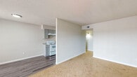 This well-appointed 1-bedroom, 1-bathroom unit is thoughtfully laid out across a single floor, offering a comfortable and functional living environment. The open living and dining area is finished with plush wall-to-wall carpeting and neutral-toned walls, creating a bright and welcoming atmosphere. A large sliding glass door floods the space with natural light and opens to a private balcony, extending the living area outdoors. The kitchen is efficiently designed with gray shaker-style cabinetry, granite-look countertops, and white appliances including an electric range, refrigerator, and dishwasher. Wood-look vinyl flooring in the kitchen adds a clean, durable contrast to the carpeted living areas. The bedroom is generously sized with soft carpeting, a window for natural light, and direct access to additional storage. The full bathroom features a tub and shower combination with white tile surround, complemented by wood-look vinyl flooring and a neutral color palette. Throughout the unit, a consistent use of soft grays and whites lends a clean, modern aesthetic, while the practical floor plan ensures a smooth and natural flow between all areas of the home.