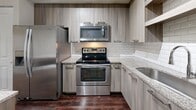 Located at 100 NW 33rd Avenue in Pompano Beach, FL, this 730-square-foot single-floor apartment offers 3 bedrooms, 1 bathroom, and a well-designed layout across one level. Dark hardwood-style flooring runs throughout, creating a cohesive and modern aesthetic.

The combined kitchen and living room serves as the heart of the unit. The kitchen is outfitted with stainless steel appliances — including a refrigerator, range, microwave, and dishwasher — complemented by granite countertops, a central island, light wood cabinetry, and a subway tile backsplash. Track lighting adds a contemporary touch. The living room benefits from a ceiling fan and a sliding glass door that opens to a lush outdoor view, filling the space with natural light.

The three bedrooms feature the same hardwood-style flooring, neutral walls, and ceiling fans. The primary bedroom measures 120 square feet and includes a closet. Secondary bedrooms offer windows with views of the surrounding greenery. Two closets with wire shelving systems provide organized storage throughout the unit.

The bathroom is well-appointed with large-format wall tiles, a walk-in shower, a separate soaking tub, and recessed lighting, offering both style and functionality in a clean, neutral palette.