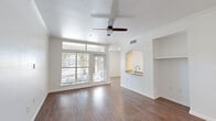Located at 1100 Henderson St in Fort Worth, TX, this one-bedroom, one-bathroom residence offers a well-designed single-floor layout with a thoughtful blend of comfort and style. The open living area is anchored by rich, dark hardwood-style flooring, crown molding, and a ceiling fan, while large windows and a glass-panel door flood the space with natural light and offer views of the surrounding greenery. A distinctive arched pass-through connects the living area to the kitchen, which features white cabinetry, granite countertops, a subway tile backsplash, stainless steel appliances, and matching hardwood-style floors — creating a clean, contemporary feel. A built-in niche shelf adds a functional architectural touch to the living space. The bedroom is carpeted for comfort, outfitted with its own ceiling fan, and benefits from a generous walk-in closet with multi-tier wire shelving for ample storage. The bathroom continues the polished aesthetic with granite countertops, white cabinetry, a wide vanity mirror, and hardwood-style flooring. A dedicated entrance, hallway, and additional closet round out the efficient and complete floor plan of this well-appointed Fort Worth residence.