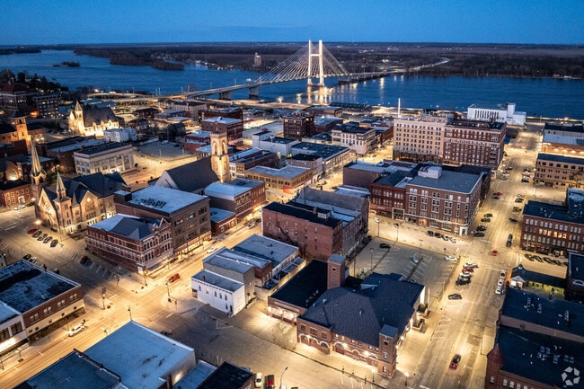 An aerial view of Burlington at night with the Mississippi River in the distance.