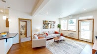 Located at 16727 E Desmet Ct in Spokane Valley, WA, this thoughtfully designed 2-bedroom, 2-bathroom residence offers a comfortable and functional single-floor layout. Warm hardwood-style flooring flows throughout the main living areas, complemented by clean white walls and wood-trimmed doors and accents that lend a cohesive, modern aesthetic.

The open-concept kitchen and dining area is a practical centerpiece, featuring warm wood cabinetry, stainless steel appliances, a dark-countertop breakfast bar with pendant lighting, and ample recessed lighting overhead. The adjacent dining space comfortably accommodates a full dining set. The living room is bright and inviting, with large windows framing outdoor greenery and allowing generous natural light to fill the space.

A glass-paneled entry door opens to a welcoming foyer with additional windows, enhancing the sense of openness. The spacious primary bedroom includes a large sliding-door closet and plush carpeting, while the second bedroom also features a sliding closet and comfortable proportions. Both bathrooms are clean and functional, each with a shower-tub combination. Three closets throughout the unit provide ample storage. A private patio rounds out this well-equipped residence.