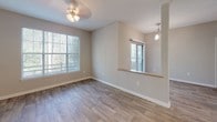 Located in Carrboro, NC, this single-floor residence offers a thoughtfully designed layout that balances comfort and functionality. The open living area greets you with warm wood-style flooring, neutral-toned walls, and generous windows that flood the space with natural light while offering views of surrounding greenery. A ceiling fan adds a practical touch to the living space, which connects seamlessly to a dining area framed by a pass-through window and a pendant light, with a sliding glass door providing access to an outdoor balcony.

The kitchen is efficiently arranged with white cabinetry, light countertops, a stainless steel refrigerator, and an electric range, offering ample storage and workspace. Track lighting overhead ensures the kitchen is well-lit for everyday use. A peninsula-style counter connects the kitchen to the main living area, reinforcing the open, connected feel of the floor plan.

The bedroom is carpeted for comfort and features a large window with natural wooded views, creating a calm and restful atmosphere. The bathroom is clean and functional, with a tiled shower/tub combination accented by a classic black-and-white tile border, wood-style flooring, and a vanity with light countertops. Throughout the residence, neutral finishes and consistent design elements create a cohesive, move-in-ready environment.