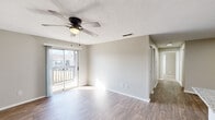 This single-story residence on Curtis Ln SE in Cleveland, Tennessee offers a thoughtfully designed layout across a compact yet efficient floor plan. The combined kitchen and living area serves as the heart of the home, where wood-style plank flooring, neutral wall tones, and a ceiling fan create a bright, inviting atmosphere. Sliding glass doors lead to an outdoor balcony, allowing natural light to fill the living space and providing a direct connection to the exterior.

The kitchen is equipped with stainless steel appliances, including a range, microwave, and refrigerator, complemented by white shaker-style cabinetry and granite countertops. A built-in overhead light panel adds practical illumination to the workspace.

The two bedrooms feature ceiling fans and natural light from windows with blinds. The primary bedroom is carpeted, providing a softer underfoot feel, while the second bedroom showcases wood-style flooring. All three bathrooms are finished consistently, each featuring granite-topped vanities and tub-shower combinations with large-format marble-style tile surrounds and brushed nickel fixtures. The textured ceilings and clean white trim complete the cohesive, move-in-ready aesthetic throughout.