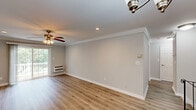 Located at Fairfield Sunrise Gardens in Bohemia, NY, this two-floor residence combines classic architectural details with contemporary updates throughout. The main living area is bright and welcoming, featuring warm hardwood-style flooring, elegant crown molding, recessed lighting, and a ceiling fan. Sliding glass doors open to an outdoor balcony, filling the space with natural light and providing a seamless indoor-outdoor connection.

The kitchen is well-equipped with rich wood cabinetry, a dark granite tile backsplash, light hardwood-style flooring, and a full suite of stainless steel appliances including a refrigerator, range, microwave, and dishwasher. A staircase finished in light wood planks with a classic metal railing connects the two floors with style and function.

The upper level features carpeted bedrooms adorned with crown molding, ceiling fans, recessed lighting, and ample closet space. One bedroom offers a window with natural views, while another benefits from access to a bathroom featuring a rich wood vanity with dark granite countertops and tile flooring. Additional rooms display hardwood-style floors, baseboard heating, and generous closet storage, rounding out a comfortable and cohesive living environment.