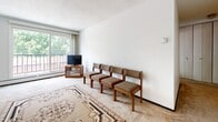 This single-floor unit offers a practical and straightforward layout across several well-defined areas. The living room serves as the central gathering space, finished with wall-to-wall carpet and a textured ceiling. A large sliding window and balcony door flood the room with natural light and provide views of surrounding greenery, creating a bright and open atmosphere. The space is open to the dining area, which connects seamlessly to the rest of the unit.

The galley-style kitchen is efficiently designed, featuring dark cabinetry contrasted by light marble-look countertops and a tile backsplash with a subtle geometric pattern. Wood-look flooring runs underfoot, and white appliances including a gas range and refrigerator complete the functional setup.

The unit includes two bedrooms, both carpeted and finished with white walls and textured ceilings. One bedroom features a window overlooking the balcony area, while the other includes a built-in closet with bifold doors, offering useful storage. Both rooms are quiet and simply appointed.

The bathroom is compact and clean, equipped with a single-sink vanity with white cabinetry, a mirrored medicine cabinet, and a tub-shower combination. The overall unit presents a functional and livable space with practical finishes throughout.