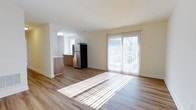 Located at 495 Nutt Rd in Phoenixville, Pennsylvania, this single-floor residence offers a clean, modern living experience with a thoughtfully designed open-concept layout. The living area is bright and airy, bathed in natural light that streams through a large sliding glass door, which also provides direct access to the outdoors. Warm hardwood-style flooring runs throughout, adding a sense of continuity and warmth to the space.

The kitchen flows seamlessly from the living area and is outfitted with contemporary finishes, including white upper cabinetry, rich wood-toned lower cabinets, and stainless steel appliances — highlighted by a full-size refrigerator. A pass-through or partial partition between the kitchen and living space maintains an open feel while providing subtle visual separation between the two functional zones.

The overall color palette is light and neutral, with soft cream-toned walls and white trim that enhance the sense of openness. Recessed and flush-mount lighting supports the natural light, ensuring the space remains well-lit throughout the day. The combination of modern appliances, durable flooring, and an abundance of natural light makes this a functional and inviting single-floor home in the heart of Phoenixville.