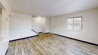 This two-story residence in Wichita, Kansas offers a practical and functional layout spread across two floors. The main level features a bright, open living room with light wood-look laminate flooring, textured ceilings, and windows that allow natural light to fill the space. A pass-through window connects the living area to the kitchen, which is equipped with warm honey-toned wood cabinetry, a double-basin stainless steel sink, electric range, dishwasher, and refrigerator, all complemented by laminate countertops. Additional closet storage is conveniently located within the kitchen area. A staircase leads to the upper floor, where all three bedrooms are situated. Each bedroom features plush carpeting, closets, and windows that bring in natural light. The primary bedroom offers a generous footprint among the three. The full bathroom is located upstairs and includes a single-sink vanity with wood cabinetry, a large mirror, and a shower-tub combination. A hallway connects the upstairs rooms and provides access to all bedrooms. Throughout, the home maintains a clean, neutral palette with white walls and textured ceilings, creating a simple and move-in-ready environment.