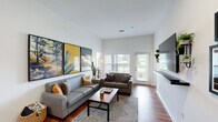 Located at 800 W Hovey Ave in Normal, IL, this well-appointed unit offers four bedrooms and four full bathrooms across a single floor, providing a functional and comfortable layout. The open living room features high ceilings, large windows that invite abundant natural light, hardwood-style flooring, and direct access to an outdoor area, creating a bright and welcoming atmosphere. The fully equipped kitchen is a standout feature, boasting generous U-shaped cabinetry in warm wood tones, granite-style countertops, black appliances including a refrigerator, range, microwave, and dishwasher, plus a skylight that further brightens the space. An adjacent dining area adds convenience for everyday living. Each of the four bedrooms is carpeted, fitted with a ceiling fan, and includes its own dedicated closet, offering privacy and comfort for all occupants. The bedrooms are well-lit by large windows with outdoor views. Each bedroom is paired with its own full bathroom, featuring tiled tub-shower combinations, wood-toned cabinetry, and granite-style vanity countertops. The layout is thoughtfully designed to maximize shared and private spaces alike, making this unit an ideal choice for those seeking a well-structured, multi-occupant residence in Normal, IL.