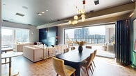 Located at 1904 Hayes Street in Nashville, TN, this upscale rooftop space offers a seamless blend of contemporary interior design and open-air living. The interior is anchored by a combined living and dining area, where a striking dark-finished dining table surrounded by velvet upholstered chairs takes center stage beneath a sculptural brass and globe chandelier. A dedicated wet bar with an eye-catching geometric tile backsplash adds a refined entertaining touch. The living area features a bold dark stone accent wall housing a wall-mounted television, complemented by a layered rug, plush seating, and warm pendant lighting. A separate lounge nook with built-in banquette seating adds an intimate corner for smaller gatherings. Wood-look tile flooring runs throughout, while large glass folding doors dissolve the boundary between indoors and out. The expansive rooftop terrace is a standout feature, offering generous deck space outfitted with multiple seating arrangements, a long communal dining table, and a louvered pergola overhead. The terrace commands panoramic views of the Nashville skyline, making it an exceptional setting for events and gatherings in the heart of Midtown.