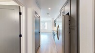 Located at 6010 Alpine Vista Cir in Castle Rock, CO, this two-bedroom, one-bathroom unit offers a thoughtfully designed single-floor layout with contemporary finishes throughout. The open kitchen and living area serves as the heart of the space, featuring gray shaker-style cabinetry with matte black hardware, white quartz countertops, a subway tile backsplash, and a full suite of stainless steel appliances including a range, over-the-range microwave, dishwasher, and French door refrigerator. Light wood-look flooring runs throughout the main living areas, lending a clean and cohesive aesthetic. The living area is filled with natural light from large windows offering views of the surrounding building exterior. The primary bedroom is a well-proportioned retreat with soft carpeting, a ceiling fan, and a generously sized walk-in closet with built-in shelving. The second bedroom features the same light wood flooring and a large window that invites natural light. The bathroom is finished with a dark-toned vanity with a white countertop, black hardware accents, a mirror, and hardwood-style flooring. Recessed lighting and neutral white walls throughout create a bright, move-in-ready environment suited for modern living in the Castle Rock community.