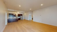 This single-floor residence in New Orleans offers a thoughtfully designed layout with three bedrooms and two bathrooms. Light-toned hardwood flooring runs throughout the living areas and bedrooms, lending a clean, contemporary aesthetic to the entire space.

The open-concept living and kitchen area forms the heart of the home. The kitchen is well-appointed with rich dark wood cabinetry, marble-style countertops and backsplash, stainless steel appliances including a French-door refrigerator and slide-in range, a stainless vent hood, and a central island with an undermount sink. Recessed lighting and pendant fixtures illuminate the space effectively.

The primary bedroom features tall ceilings, a ceiling fan, and glass French doors opening to an outdoor balcony. A spacious walk-in closet with full-length shelving and hanging rods provides ample storage. Additional bedrooms are bright and generously sized, with one featuring a skylight that draws in natural light.

The primary bathroom is finished with large-format marble-look tile flooring, a glass-enclosed shower, soaking tub with marble surround, dark vanity, and a built-in linen closet. An in-unit laundry area with a stacked Whirlpool washer and dryer completes the home.