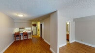 Located at 2681 Jefferson St in Norman, Oklahoma, this single-floor unit offers a functional and comfortable layout designed for everyday living. The main living area is bright and open, showcasing warm hardwood flooring that extends throughout the space. A tiled fireplace serves as a focal point, flanked by a set of French doors that flood the room with natural light and provide direct access to the outdoors. The open-concept kitchen is efficiently arranged with rich wood cabinetry, light-toned countertops, a full suite of white appliances including a dishwasher, microwave, and refrigerator, as well as a stainless steel sink positioned beneath a window. A peninsula with bar seating connects the kitchen to the living area, making it ideal for casual dining or entertaining. A hallway leads to the private areas of the unit, including a bathroom finished with tile flooring, a vanity with a light stone countertop, and built-in shelving for added storage. The walk-in closet offers generous storage capacity with full-length hanging rods and multiple shelves. Textured ceilings are present throughout, and the neutral wall tones provide a clean, versatile backdrop across all rooms.