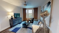 This thoughtfully designed single-floor residence in Mansfield, TX offers a cohesive blend of modern style and functional living. The open-concept kitchen is a standout feature, boasting dark espresso cabinetry, granite countertops, stainless steel appliances, and a spacious island with pendant lighting and bar seating — ideal for cooking and entertaining alike. Wood-look flooring flows throughout the main living areas, adding warmth and continuity.

The living area is bright and inviting, featuring large windows dressed with floor-to-ceiling drapes that allow generous natural light while framing outdoor views. A ceiling fan, stylish furnishings, and a bold geometric area rug create an eclectic yet sophisticated atmosphere.

The primary bedroom is generously sized with large windows, plush carpet, and elegant décor, while a second bedroom offers similar comfort with its own natural light and carpeted flooring. The primary bathroom features a glass-enclosed walk-in shower, dark wood vanity with granite countertops, and wood-look tile flooring. A second full bathroom includes a tiled shower-tub combination and matching granite vanity. Together, these spaces reflect a consistent design language that is contemporary, refined, and highly livable.