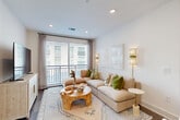 Located at 285 Mayson Ave NE in Atlanta's vibrant 30307 zip code, this well-appointed 2-bedroom, 2-bathroom single-floor residence offers a thoughtfully designed layout across a comfortable footprint. The open-concept living, dining, and kitchen area serves as the heart of the home, bathed in natural light from a large sliding glass door that opens to a private balcony with outdoor views. The living area features recessed lighting and rich hardwood-style flooring that flows throughout the space.

The modern kitchen is outfitted with sleek white cabinetry extending to the ceiling, dark granite countertops, a marble-style tile backsplash, and a full suite of stainless steel appliances, including a French door refrigerator, range, microwave, and dishwasher. A breakfast bar with seating connects seamlessly to the dining area.

Both bedrooms offer generous proportions, large windows for natural light, and access to well-organized walk-in closets with multi-tier wire shelving systems. The bathrooms are finished with large-format marble-look tile flooring, dark countertops, floating vanities, and bright vanity lighting. A dedicated laundry room and ample hallway storage round out this functional and stylish Atlanta residence.