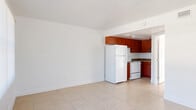 Located at 12401 North 15th Street in Tampa, FL, this single-story, one-bedroom, one-bathroom unit offers a functional and efficient layout. Light-toned ceramic tile flooring runs consistently throughout the entire space, lending a clean, cohesive look to every room.

The living area is bright and open, benefiting from a large sliding glass door that invites natural light and provides a view of the outdoors. A side window further enhances the airy atmosphere. The space flows seamlessly into the kitchen, which is partially separated by a half-wall partition. The kitchen is equipped with rich, warm-toned wood cabinetry, dark stone-style countertops, a white refrigerator, and a white range, creating a practical cooking environment.

The bedroom is a comfortable, well-proportioned room featuring multiple windows dressed with horizontal blinds, allowing for ample natural light and outdoor views. A built-in closet with double panel doors provides convenient storage space.

The bathroom is clean and simply appointed, featuring a combination tub and shower with a white surround, a white vanity with an under-mount sink, chrome fixtures, and a wall-mounted mirror. The overall design of the space is straightforward and bright, making it a practical and livable unit in the heart of Tampa.