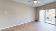 Located at 1402 Bridford Pkwy in Greensboro, NC, this single-story, one-bedroom, one-bathroom residence offers a well-designed layout that maximizes its compact footprint. The open-concept living and kitchen area is anchored by light hardwood-style flooring, neutral warm-toned walls, and a ceiling fan that promotes airflow throughout. A sliding glass door leads to a private balcony, filling the living space with natural light and outdoor views.

The kitchen is well-appointed with white shaker-style cabinetry, granite-look countertops, stainless steel appliances including a refrigerator, electric range, microwave, and dishwasher, and light hardwood-style flooring that complements the living area seamlessly.

The bedroom features plush carpeting, a ceiling fan with a window overlooking the outdoors, and ample room for furnishings. A dedicated closet provides convenient storage. The bathroom includes a full tub-shower combination with tiled surround. A separate laundry area accommodates a full-size washer and dryer, adding practical convenience. Clean white trim and a consistently neutral color palette give the entire space a cohesive, move-in-ready aesthetic.