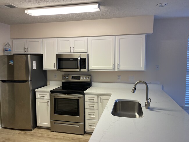 New quartz counter tops with new kitchen cabinets. - 612 Waterway Village Blvd