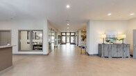 Located at 1108 Carriage Knoll Ln in Columbus, Ohio, this single-floor community clubhouse spans a generous footprint designed to accommodate a variety of social and wellness activities. The welcoming lobby greets visitors with large-format tile flooring, recessed lighting, a prominent branded wall feature, and comfortable seating—setting an immediately polished and modern tone throughout.

The kitchen and lounge area is a standout feature, boasting an expansive granite-topped island with bar seating and clear acrylic chairs. Gray shaker cabinetry, stainless steel appliances, and bold industrial-style pendant lights overhead create a contemporary yet functional space ideal for gatherings. The adjacent living room offers a cozy retreat, centered around a floor-to-ceiling marble-clad fireplace flanked by plush seating and a metallic accent table, enveloped in rich, moody tones.

A separate lounge nook provides a more intimate setting, complete with a wall-mounted television and a classic popcorn machine, perfect for casual entertainment.

The expansive exercise room is comprehensively outfitted with treadmills, ellipticals, a cable machine, free weights, and adjustable benches. Full-length mirrors, wall-mounted televisions, ceiling fans, and natural light from large windows create an energizing and motivating workout environment. The space is thoughtfully designed to support a full range of fitness activities.