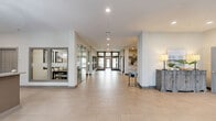 Located at 1108 Carriage Knoll Ln in Columbus, Ohio, this single-floor community clubhouse spans a generous footprint designed to accommodate a variety of social and wellness activities. The welcoming lobby greets visitors with large-format tile flooring, recessed lighting, a prominent branded wall feature, and comfortable seating—setting an immediately polished and modern tone throughout.

The kitchen and lounge area is a standout feature, boasting an expansive granite-topped island with bar seating and clear acrylic chairs. Gray shaker cabinetry, stainless steel appliances, and bold industrial-style pendant lights overhead create a contemporary yet functional space ideal for gatherings. The adjacent living room offers a cozy retreat, centered around a floor-to-ceiling marble-clad fireplace flanked by plush seating and a metallic accent table, enveloped in rich, moody tones.

A separate lounge nook provides a more intimate setting, complete with a wall-mounted television and a classic popcorn machine, perfect for casual entertainment.

The expansive exercise room is comprehensively outfitted with treadmills, ellipticals, a cable machine, free weights, and adjustable benches. Full-length mirrors, wall-mounted televisions, ceiling fans, and natural light from large windows create an energizing and motivating workout environment. The space is thoughtfully designed to support a full range of fitness activities.
