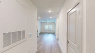 Located at 125 New Hanover St in Beaufort, SC, this efficiently designed one-bedroom, one-bathroom unit offers a clean, modern aesthetic throughout its single floor. Light-toned wood-look flooring runs continuously through the main living areas, complementing the crisp white walls and recessed lighting that keep the space feeling bright and open.

The kitchen is well-appointed with white shaker-style cabinetry extending to the ceiling, granite countertops, a subway tile backsplash, and a full suite of stainless steel appliances including a refrigerator, range, microwave, and dishwasher. It opens naturally toward the living area, which is anchored by a ceiling fan and a window offering views of surrounding greenery.

The bedroom is a comfortable, light-filled room with its own ceiling fan, a window with blinds, and direct access to a generously sized walk-in closet outfitted with wire shelving systems for organized storage. The bathroom features a tiled tub-shower combination, wood-look flooring, and granite-topped vanity. A dedicated laundry room houses a full-size Whirlpool washer and dryer set alongside additional wire shelving for utility storage. This unit delivers a practical yet polished living experience in a convenient Beaufort location.