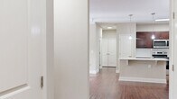 Located at 1001 Amelia Station Way in Clayton, NC, this well-appointed single-story, 3-bedroom, 2-bathroom home offers a thoughtfully designed layout with a clean, neutral aesthetic throughout. Rich hardwood flooring flows through the open-concept combined dining and living area, which is highlighted by crown molding, a ceiling fan, and French doors that lead to a private patio, bringing in natural light and outdoor connectivity. The kitchen is a standout feature, showcasing deep-toned hardwood cabinetry, white countertops, a tile backsplash, and stainless steel appliances, including a refrigerator with an ice and water dispenser and a range with microwave. A dedicated pantry adds to the kitchen's functionality. The bedrooms are carpeted for comfort, each offering natural light through window blinds and ceiling fans. The generously sized primary bedroom includes its own walk-in closet. Secondary bedrooms also feature closet storage. Both bathrooms are finished with rich wood vanities, white countertops, and tile flooring, with one featuring a tub-shower combination. A utility room and dedicated entrance round out this practical and comfortable home.