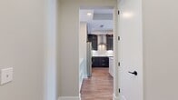 This 680 square foot apartment offers a thoughtful layout maximizing space efficiency. The single-floor design features one bedroom measuring 150 square feet, complemented by two full bathrooms for added convenience. The heart of the home is an open-concept kitchen and living room area, creating a spacious feel within the compact footprint.

The interior is characterized by warm wood flooring throughout, providing a cohesive and inviting ambiance. Recessed lighting in the ceiling adds a modern touch while ensuring even illumination. Large windows, as seen in the image, allow ample natural light to flood the space, enhancing the perception of roominess.

The apartment includes two hallways for easy navigation and a closet for storage. The neutral wall color creates a blank canvas for personalization. The glimpse into what appears to be a bathroom reveals dark wood cabinetry, suggesting a tasteful and contemporary finish to the utilitarian spaces.

This apartment is ideal for those seeking a well-designed, low-maintenance living space that maximizes functionality without compromising on style or comfort.