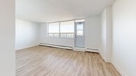 Located at 25 Fisherville Rd in Toronto's North York neighbourhood, this well-appointed 2-bedroom, 1-bathroom unit offers a clean, modern aesthetic throughout its thoughtfully designed single floor. Light wood laminate flooring flows seamlessly across all living spaces, complementing the crisp white walls and creating a bright, airy atmosphere.

The spacious living room is bathed in natural light through large floor-to-ceiling windows and features baseboard heating, with direct access to a private balcony that boasts expansive panoramic views of the Toronto skyline and surrounding tree-lined neighbourhoods. The kitchen is outfitted with white shaker-style cabinetry, dark countertops, a subway tile backsplash, and stainless steel appliances including a dishwasher.

The generously sized primary bedroom features a large window with outdoor views and baseboard heating, while the second bedroom includes a built-in sliding door closet, offering practical storage. Both rooms share access to a hallway with an additional dedicated closet. The bathroom is finished with classic white subway tile surrounding a full soaker tub and shower combination with chrome fixtures. The unit's clean, minimalist design and abundant natural light make it a comfortable and functional living space.