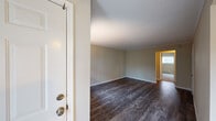 This single-floor unit offers a clean and functional layout with a thoughtful mix of finishes throughout. The main living area makes a strong first impression with rich, dark hardwood-style flooring, neutral-toned walls, and a textured ceiling that adds visual depth. Natural light filters in through windows fitted with vertical blinds, while baseboard heaters ensure year-round comfort. The space flows seamlessly toward additional rooms, providing a sense of openness throughout.

The kitchen is a standout feature, showcasing light granite countertops with subtle veining, crisp white cabinetry with contemporary hardware, a stainless steel sink with a modern pull-down faucet, and durable wood-look flooring. Ample upper and lower cabinet storage makes this kitchen as practical as it is attractive.

The bedrooms are carpeted for warmth and comfort, each featuring neutral walls, baseboard heating, and windows that bring in natural light. One bedroom includes a sliding mirrored closet, maximizing both storage and the sense of space.

The bathroom is well-finished, featuring a tub and shower combination enclosed by sliding glass doors, a white vanity with a single sink, and wood-look flooring. A second bathroom offers similar clean finishes with a tiled tub surround. The overall ambiance is bright, neutral, and move-in ready.
