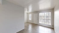 This 600 square foot single-story apartment offers a thoughtful layout maximizing space and functionality. The heart of the home is an open-concept living area, bathed in natural light from large windows. Light gray walls and modern wood-look flooring create a neutral, contemporary backdrop throughout.

The spacious primary bedroom, measuring 180 square feet, features a ceiling fan and ample closet space with a vibrant yellow interior. The efficient galley-style kitchen boasts white appliances, including a full-size refrigerator and range, complemented by light-colored cabinetry and countertops.

Large windows in the living room and bedroom not only illuminate the space but also offer views of the surroundings. The apartment's design emphasizes openness, with smooth transitions between rooms enhancing the sense of space. Ceiling fans in both the living area and bedroom provide air circulation and comfort.

This apartment combines practicality with style, offering a cozy yet modern living space ideal for individuals or couples seeking a low-maintenance home in Houston's North Freeway area.