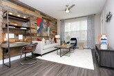 Located in the vibrant Grant Park neighborhood of Atlanta, Georgia, this single-floor residence offers a well-appointed layout with thoughtfully designed spaces throughout. The living room serves as a focal point of the home, anchored by a dramatic floor-to-ceiling reclaimed wood accent wall that adds warmth and texture. Light wood-style flooring, a ceiling fan, and large windows with patterned curtains contribute to a bright, contemporary atmosphere.

The kitchen is a standout feature, outfitted with stainless steel appliances including a French door refrigerator, electric range, over-the-range microwave, and dishwasher. Granite-style countertops, a subway tile backsplash, rich wood-toned cabinetry, open shelving, and a kitchen island complete the well-equipped space.

Multiple bedrooms provide varied and characterful retreats. One bedroom features a bold teal accent wall with stylish wall sconces and direct access to a bathroom. Another bedroom opens to the outdoors through floor-length glass doors framed by warm golden curtains, inviting abundant natural light. A third bedroom offers a more serene, neutral aesthetic with soft carpet and framed wall art.

Each bedroom is complemented by generously sized walk-in closets with built-in shelving and wire rack systems, offering ample storage. The overall design blends modern finishes with eclectic, curated styling throughout.