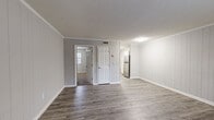 Located at 110 Village Park Dr in Simpsonville, SC, this efficient two-bedroom, one-bathroom home is thoughtfully laid out across a single floor. The open living area welcomes you with smooth hardwood-style laminate flooring, neutral gray walls, crown molding, and clean white trim that give the space a fresh, well-maintained feel. The galley-style kitchen is a standout feature, boasting white shaker cabinetry, granite-look countertops, and stainless steel appliances including a range, microwave, and refrigerator. A windowed dining nook adjacent to the kitchen provides natural light and a comfortable space for everyday meals. Both bedrooms are carpeted for warmth and comfort, each equipped with a ceiling fan and natural light from windows dressed with white blinds. The primary bedroom is generously sized and includes access to a closet as well as the shared bathroom. The bathroom features a full-size soaking tub and shower combo with chrome fixtures. Throughout the home, consistent gray tones, white doors, and updated finishes create a cohesive and move-in ready aesthetic. The single-story layout ensures easy accessibility and a practical flow between all living spaces.