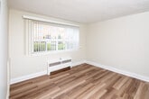 Located at 775 Concession St N in Hamilton, Ontario, this single-floor unit offers a clean, functional layout with a thoughtfully updated interior. Throughout the space, light-toned laminate flooring runs consistently, lending a sense of warmth and continuity across each room.

The living area is bright and open, benefiting from a large window fitted with vertical blinds that frame views of the surrounding neighbourhood and green space. A baseboard radiator provides in-unit heating, and the textured ceiling adds a classic residential character.

The kitchen has been renovated with crisp white cabinetry featuring brushed nickel hardware, granite-look countertops, a stainless steel sink, and a subway tile backsplash in a soft grey tone. Stainless steel appliances, including an electric range and an over-the-range microwave, complete the functional cooking space.

The bathroom is finished with full white tile surround enclosing a soaker tub with an overhead shower. A window above the tub allows for natural ventilation and light, maintaining a bright and clean atmosphere.

Additional practical features include an accessible electrical panel, a smoke detector, and a closet with sliding doors, supporting comfortable everyday living. The overall aesthetic is neutral and move-in ready, making this a practical and well-maintained space in the heart of Hamilton.