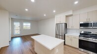 This thoughtfully designed two-story home offers 3 bedrooms and 3 bathrooms across a spacious and functional layout. The main floor provides the larger share of living space, featuring an open-concept kitchen and living area that seamlessly flow together. The kitchen is outfitted with light wood cabinetry, white quartz countertops, a central island, and a full suite of stainless steel appliances including a gas range, built-in microwave, dishwasher, and French door refrigerator. Warm hardwood-style flooring runs throughout both levels, creating a cohesive and inviting atmosphere. The living room is bright and airy, benefiting from natural light through vertical-blind windows. Upstairs, the upper floor houses the bedrooms, each featuring hardwood-style floors, neutral white walls, and windows with exterior views. The generously sized primary bedroom includes direct access to its own bathroom and a dedicated closet. Each bathroom is finished with light wood vanities, white quartz countertops, tile flooring, and modern fixtures — with the primary bath featuring a double-sink vanity and marble-accented walls. Each bedroom benefits from its own closet, with the primary suite featuring a large walk-in closet with multi-level shelving and hanging rods for ample storage.
