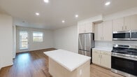 This thoughtfully designed two-story home offers 3 bedrooms and 3 bathrooms across a spacious and functional layout. The main floor provides the larger share of living space, featuring an open-concept kitchen and living area that seamlessly flow together. The kitchen is outfitted with light wood cabinetry, white quartz countertops, a central island, and a full suite of stainless steel appliances including a gas range, built-in microwave, dishwasher, and French door refrigerator. Warm hardwood-style flooring runs throughout both levels, creating a cohesive and inviting atmosphere. The living room is bright and airy, benefiting from natural light through vertical-blind windows. Upstairs, the upper floor houses the bedrooms, each featuring hardwood-style floors, neutral white walls, and windows with exterior views. The generously sized primary bedroom includes direct access to its own bathroom and a dedicated closet. Each bathroom is finished with light wood vanities, white quartz countertops, tile flooring, and modern fixtures — with the primary bath featuring a double-sink vanity and marble-accented walls. Each bedroom benefits from its own closet, with the primary suite featuring a large walk-in closet with multi-level shelving and hanging rods for ample storage.