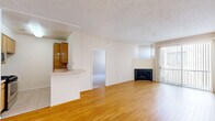 Located at 10621 Valley Spring Lane in the Studio City neighborhood of Los Angeles, CA, this single-floor residence offers a well-organized layout across a comfortable footprint. The open-concept living and dining area is finished with warm hardwood flooring and features a classic fireplace as a focal point, adding character to the space. A sliding glass door with vertical blinds fills the room with natural light and provides access to the outdoors. The galley-style kitchen is thoughtfully equipped with stainless steel appliances — including a gas range, microwave, and dishwasher — complemented by warm wood cabinetry, tile flooring, and a convenient pass-through peninsula that connects to the dining area. The two bedrooms are carpeted in neutral tones, offering a cozy atmosphere, and each includes mirrored closet doors that enhance the sense of space. Two bathrooms serve the residence; one features a bathtub and shower combination enclosed by frosted sliding glass doors, tile flooring, and a vanity with ample cabinet storage. Throughout the home, textured ceilings and clean white walls provide a neutral, move-in-ready canvas. Three closets offer generous storage options throughout the space.