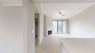 Located at 2201 South Lakeline Boulevard in Austin, Texas, this 1,090-square-foot single-floor apartment offers 2 bedrooms and 3 bathrooms across a well-organized layout. The living room is a standout space, featuring plush carpeting, crown molding, a ceiling fan, a classic white-mantled fireplace, and sliding glass doors that open to a private balcony, filling the room with natural light. The kitchen is appointed with gray shaker-style cabinetry, quartz countertops, a subway tile backsplash, wood-look flooring, and stainless steel appliances including an electric range and built-in microwave. An arched pass-through connects the kitchen to the carpeted dining area, which features a built-in wine rack. The primary bedroom spans 180 square feet, includes a ceiling fan, carpet flooring, a dedicated closet, and direct access to a private en-suite bathroom. The second bedroom is similarly sized with its own ceiling fan and en-suite bath access. The bathrooms feature wide quartz vanities, large mirrors with contemporary light fixtures, wood-look flooring, and tub-shower combos. Three closets and a dedicated utility room provide ample storage. Neutral tones and consistent finishes throughout create a cohesive and functional living environment.