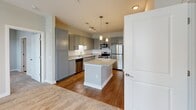 Located at 6121 Reedybrook Crossing in Apex, NC, this thoughtfully designed single-floor, 2-bedroom, 2-bathroom home offers a comfortable and functional layout. The kitchen serves as a standout feature, showcasing gray shaker-style cabinetry, a white subway tile backsplash, granite countertops, a center island with pendant lighting, and a full suite of stainless steel appliances including a refrigerator, range, microwave, and dishwasher. Hardwood-style flooring anchors the kitchen and flows into the main living areas. Both bedrooms are carpeted and bathed in natural light through large windows with blinds. The primary bedroom is generously sized, featuring a ceiling fan, an exterior door, and a walk-in closet outfitted with multi-tier wire shelving. The second bedroom is well-proportioned with its own window and ceiling fixture. The primary bathroom includes a dual-sink granite vanity with gray cabinetry, modern lighting, and hardwood-style flooring. The second bathroom mirrors the quality finishes with a granite-topped vanity and a tub-shower combination. Neutral-toned walls throughout create a clean, cohesive aesthetic suited for a variety of décor styles.
